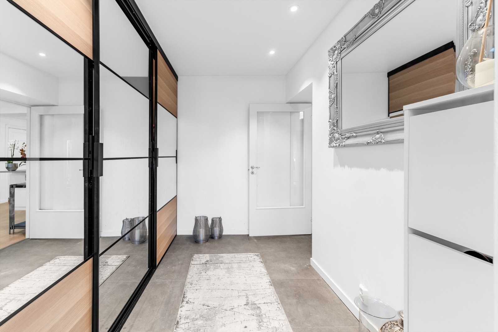 Praktisk utformet med rom for oppbevaring av sko og yttertøy, og fremstår som et funksjonelt og innbydende inngangsparti. Galleribilde