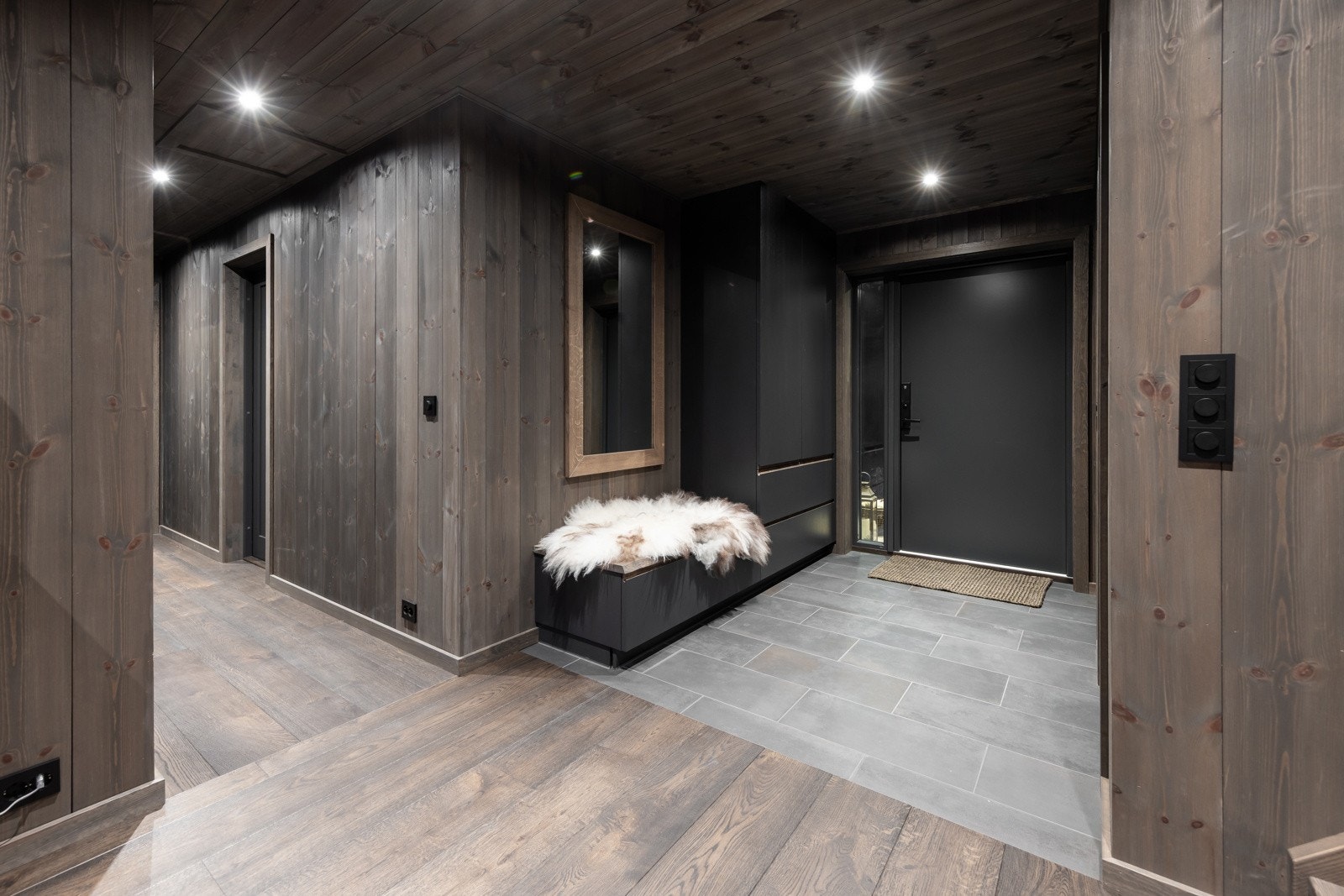 Brede svartlasserte herregårdsgulv i eik, samt bredtstående panel på veggene