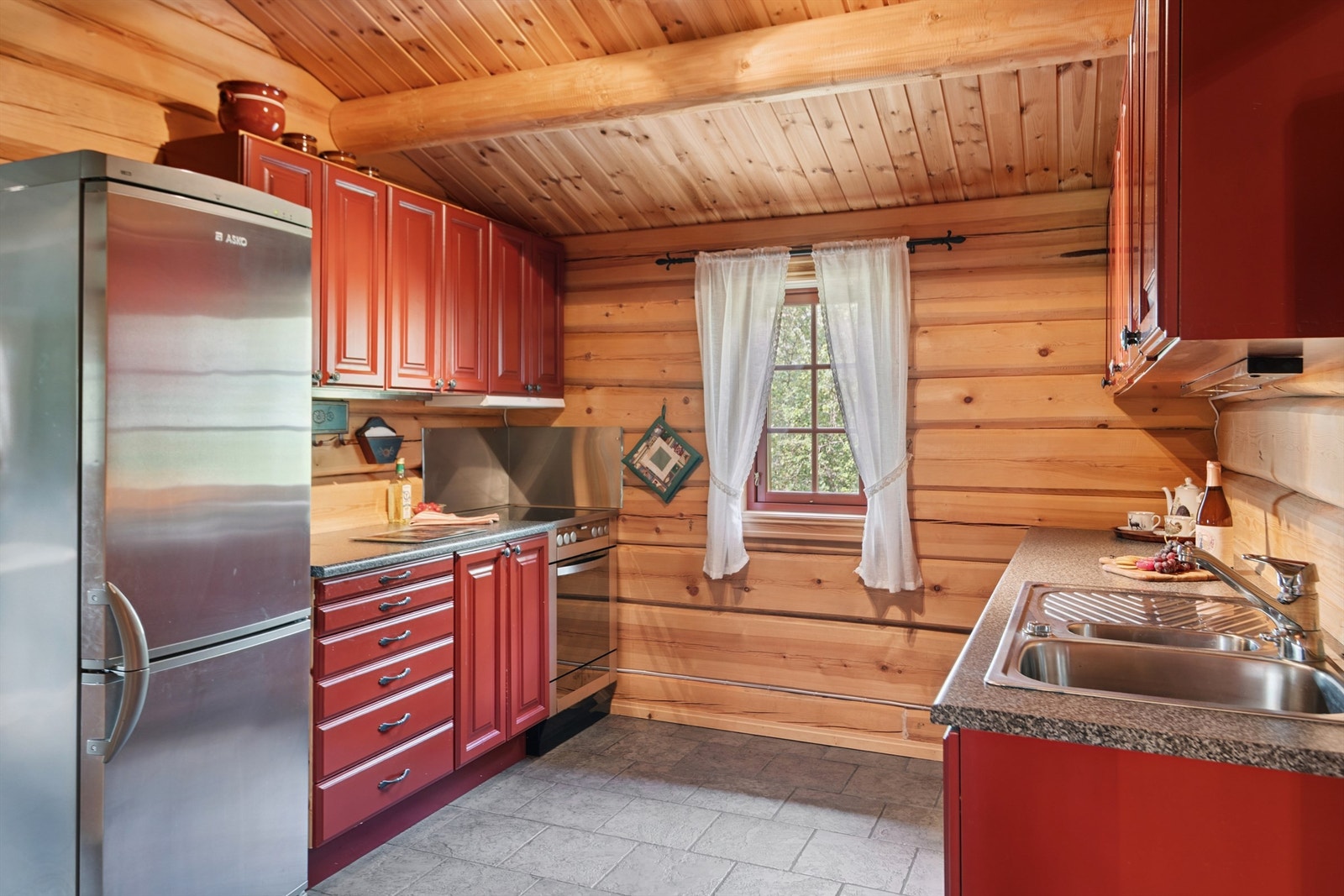 Gjennomgående tømmervegger og gulvvarme også på kjøkkenet. Galleribilde