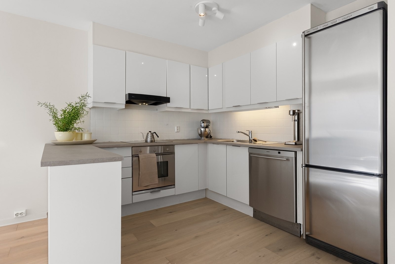 Pent innholdsrikt kjøkken med kjøkkenøy. Galleribilde