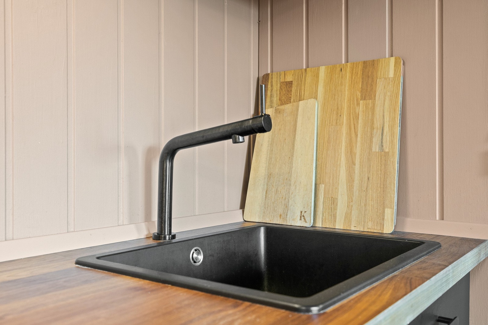 Vegg panelene på veggene er malt i samme lune jordtone som kontrastveggen i gangen og skaper en fin helhet Galleribilde