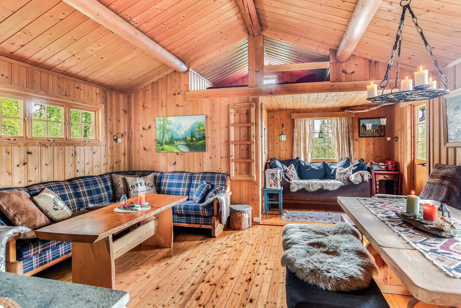 Inne i stua, hvor det er mønet himling med tømmeråser og det er utgang til terrasse, er det også adkomst til en liten hems med lav takhøyde. Galleribilde