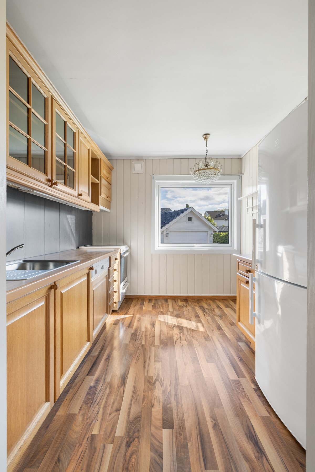 Innredningen har profilerte fronter, vitrineskap, nedfelt oppvaskkum og benkeplate av laminat. Galleribilde