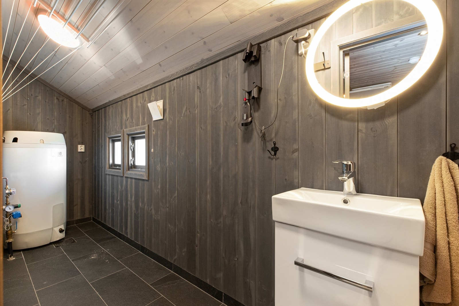 Her finnes toalett, servant med underskap, speil med tilhørende belysning, varmtvannstank og andre tekniske installasjoner. Galleribilde