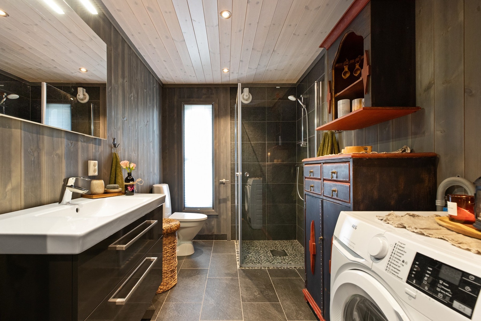 Hyttas bad har flislagt gulv, og flislagte vegger i dusjhjørnet. Galleribilde