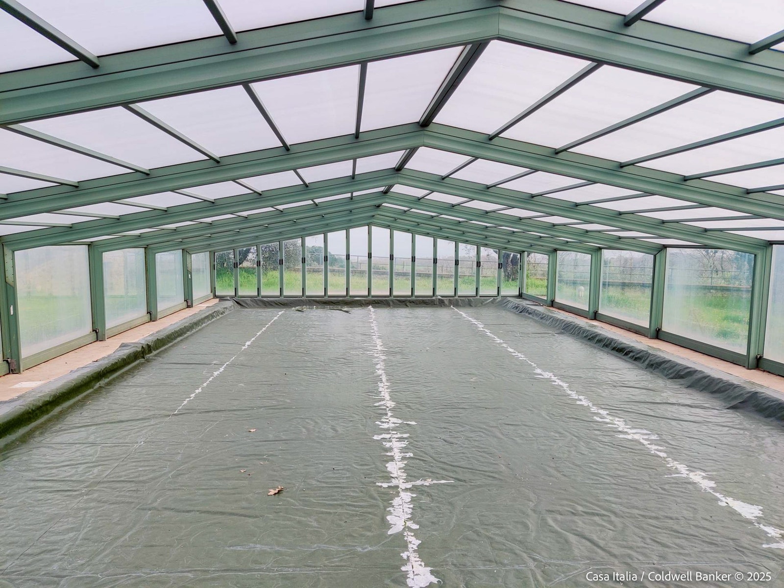 Det store, oppvarmede bassenget er overbygget for beskyttelse og sikkerhet. Her dekket til mens eierne er bortreist. Galleribilde