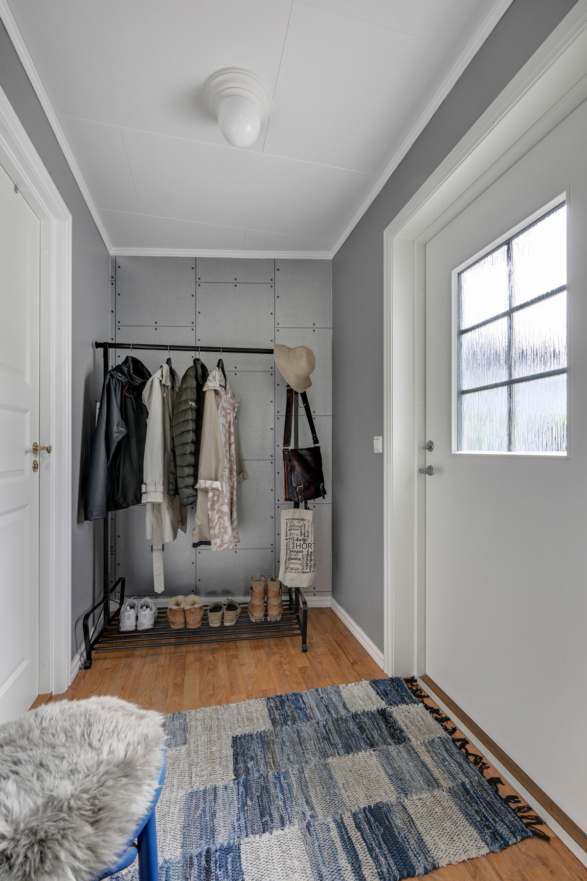 Velkommen inn i en lys og innbydende entré med plass til å sette fra seg sko og henge yttertøyet på plass Galleribilde