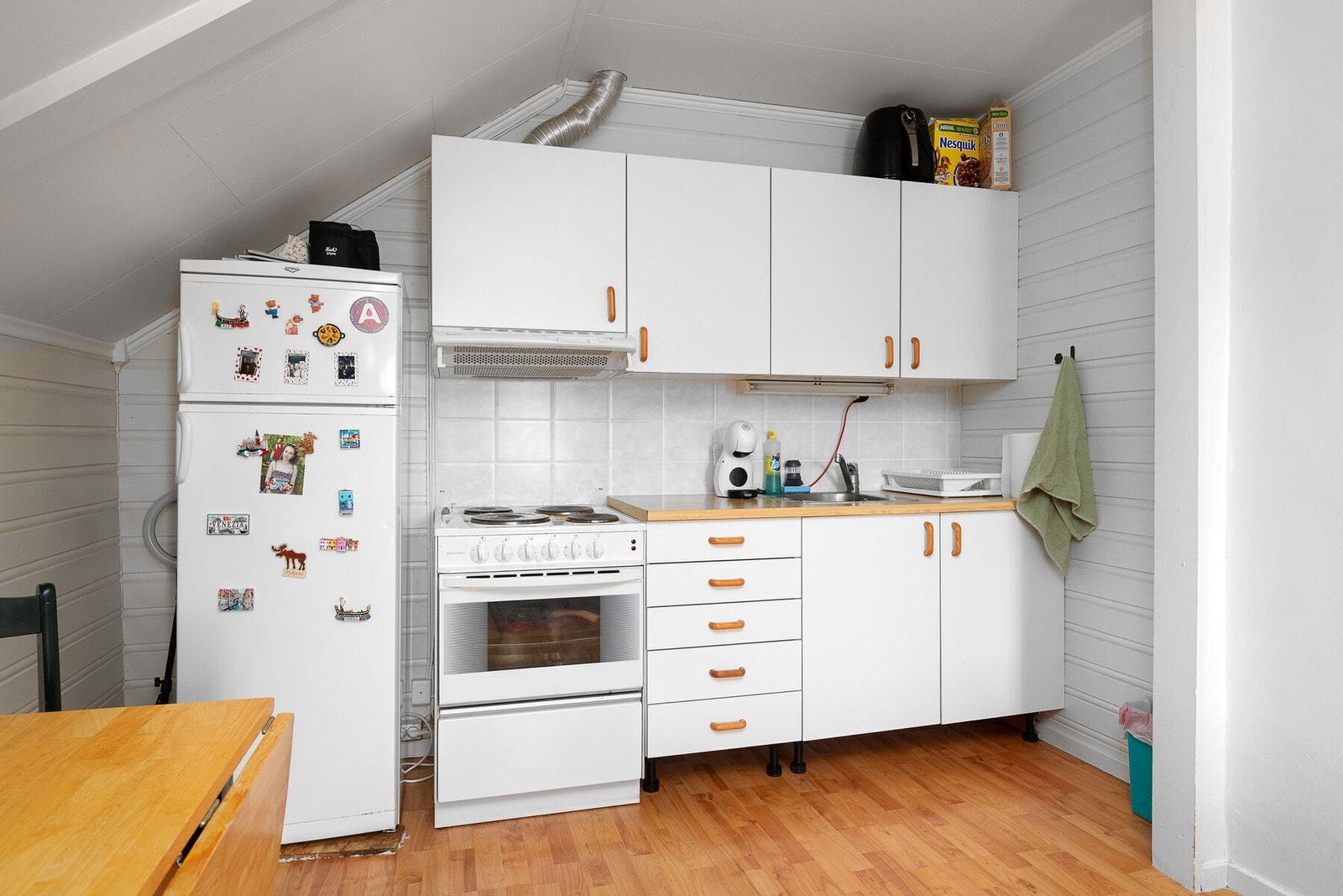 Stue og kjøkken i åpen løsning. Kjøkkenet har opplegg for frittstående hvitevarer. Galleribilde