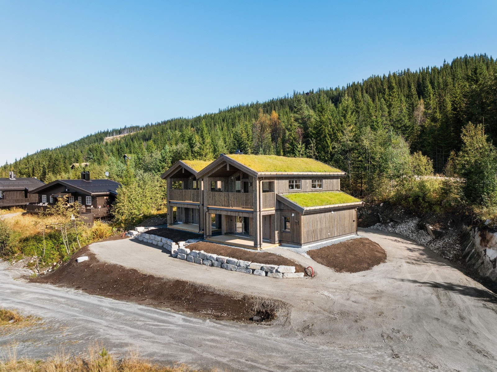 Fritidsboligen har gresstak, ekstra takhøyde og store vinduer som inviterer både lys og utsikt inn. Galleribilde