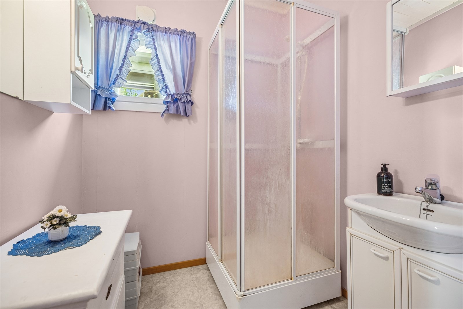 Bad fra byggeår. Innlagt vann på 90-tallet. Belegg på gulv. Malt tapet på veggoverflater. Rommet har speil, servantskap og veggskap. Servant og dusjkabinett. Portabel do. Naturlig avtrekk. Våtrommet må oppgraderes for å tåle normal bruk etter dagens krav. Galleribilde