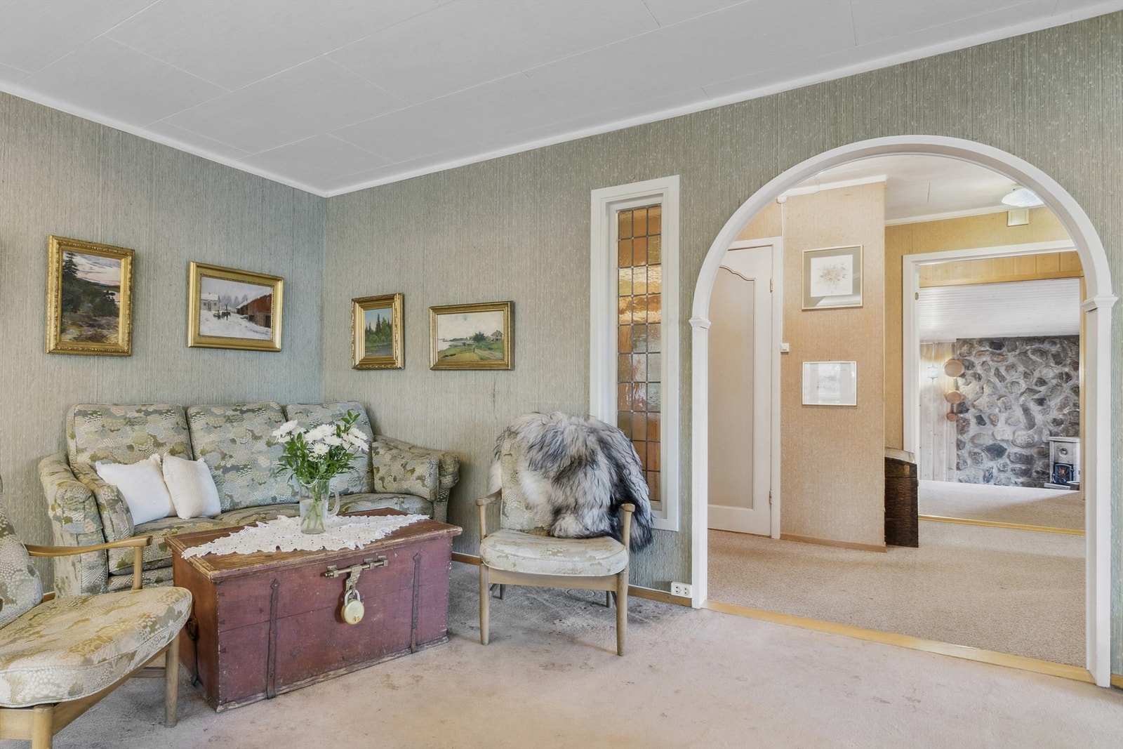 En elegant bueåpning skaper en fin forbindelse mellom peisestuen og gangen, og leder oss videre inn i boligen. Galleribilde