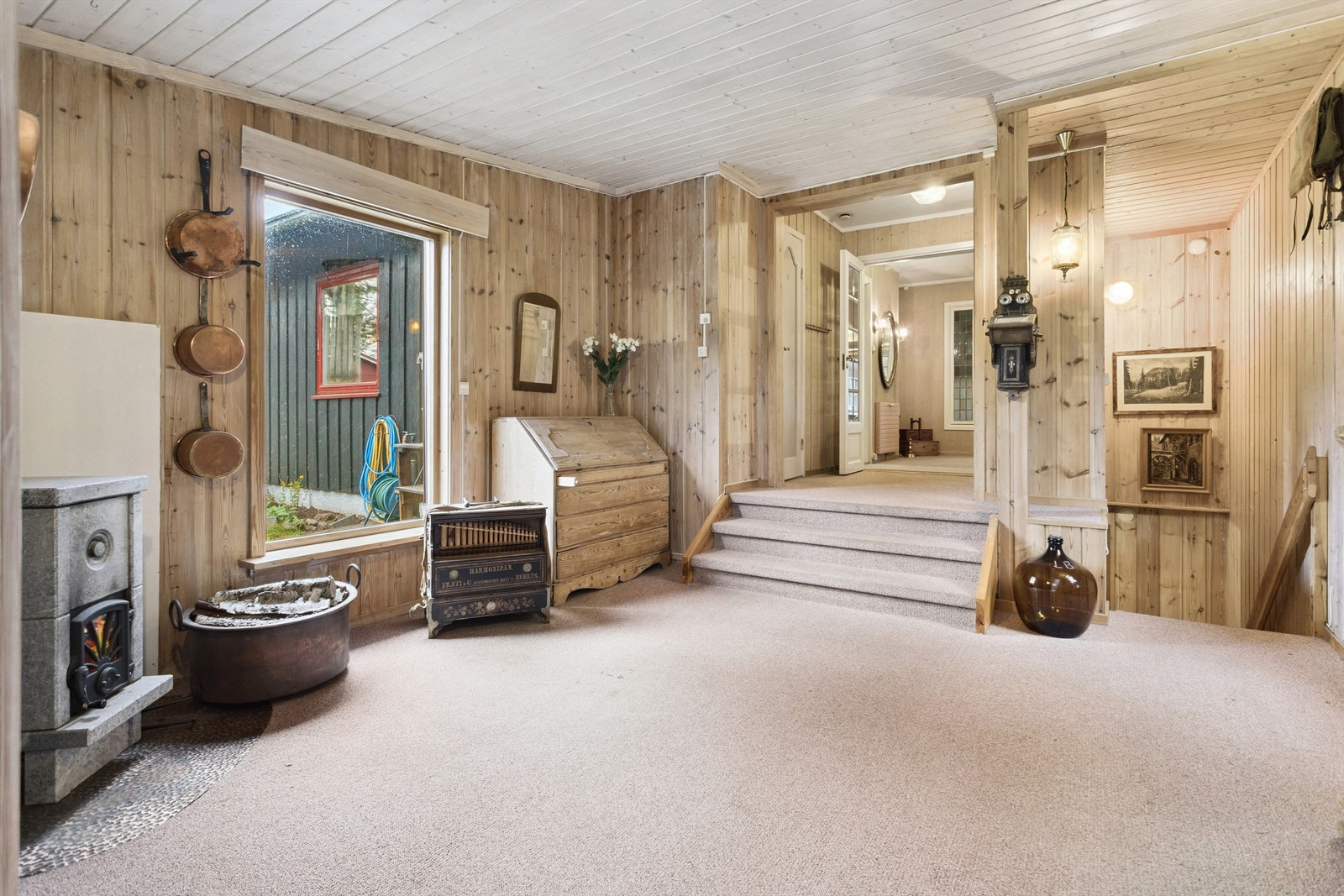 I den store hallen er det en naturlig plassering av trappen ned til kjelleren. Her sørger en klebersteinsovn for ekstra varme og hyggelig atmosfære. Galleribilde