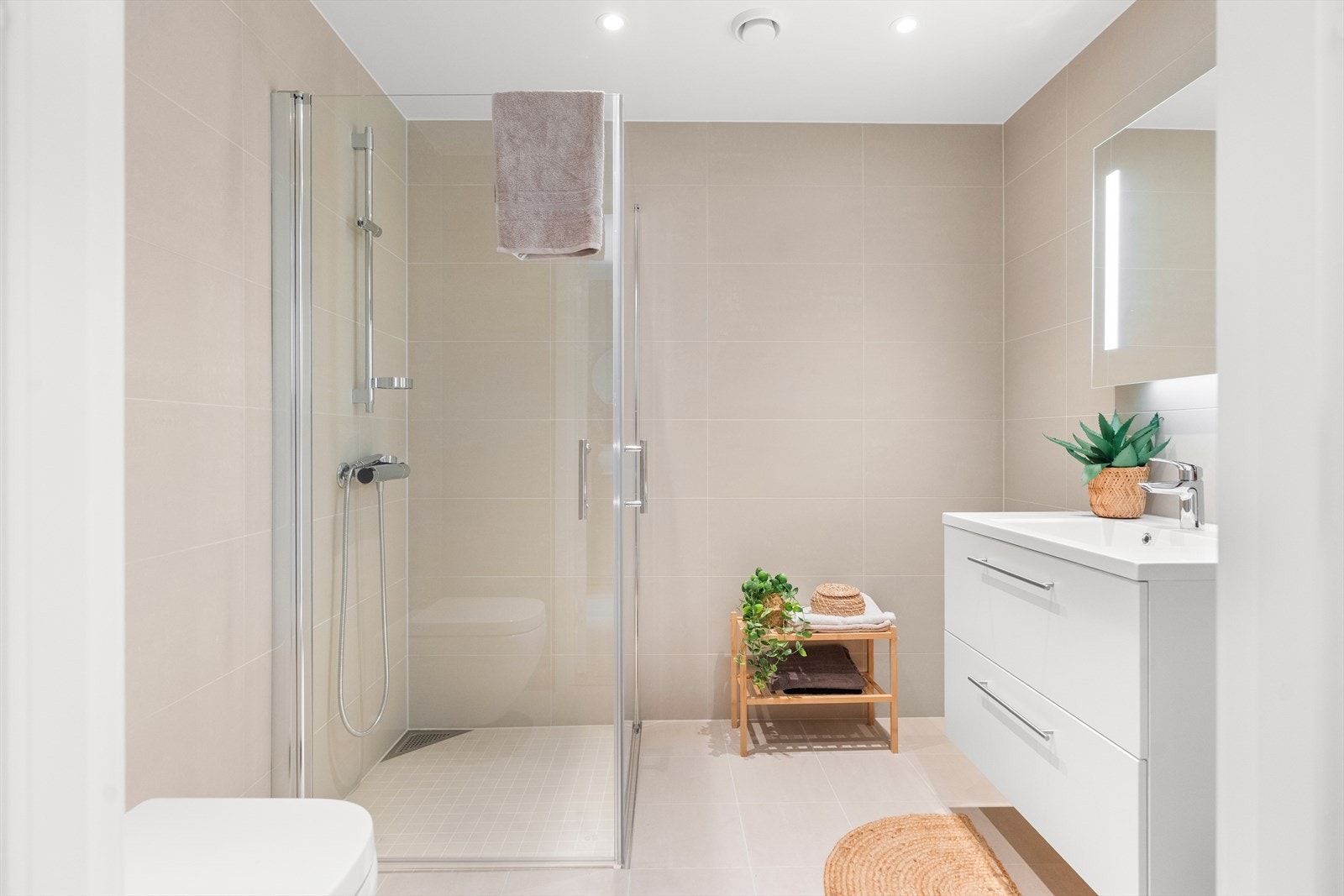 Leiligheten har et lekkert, flislagt bad. Galleribilde