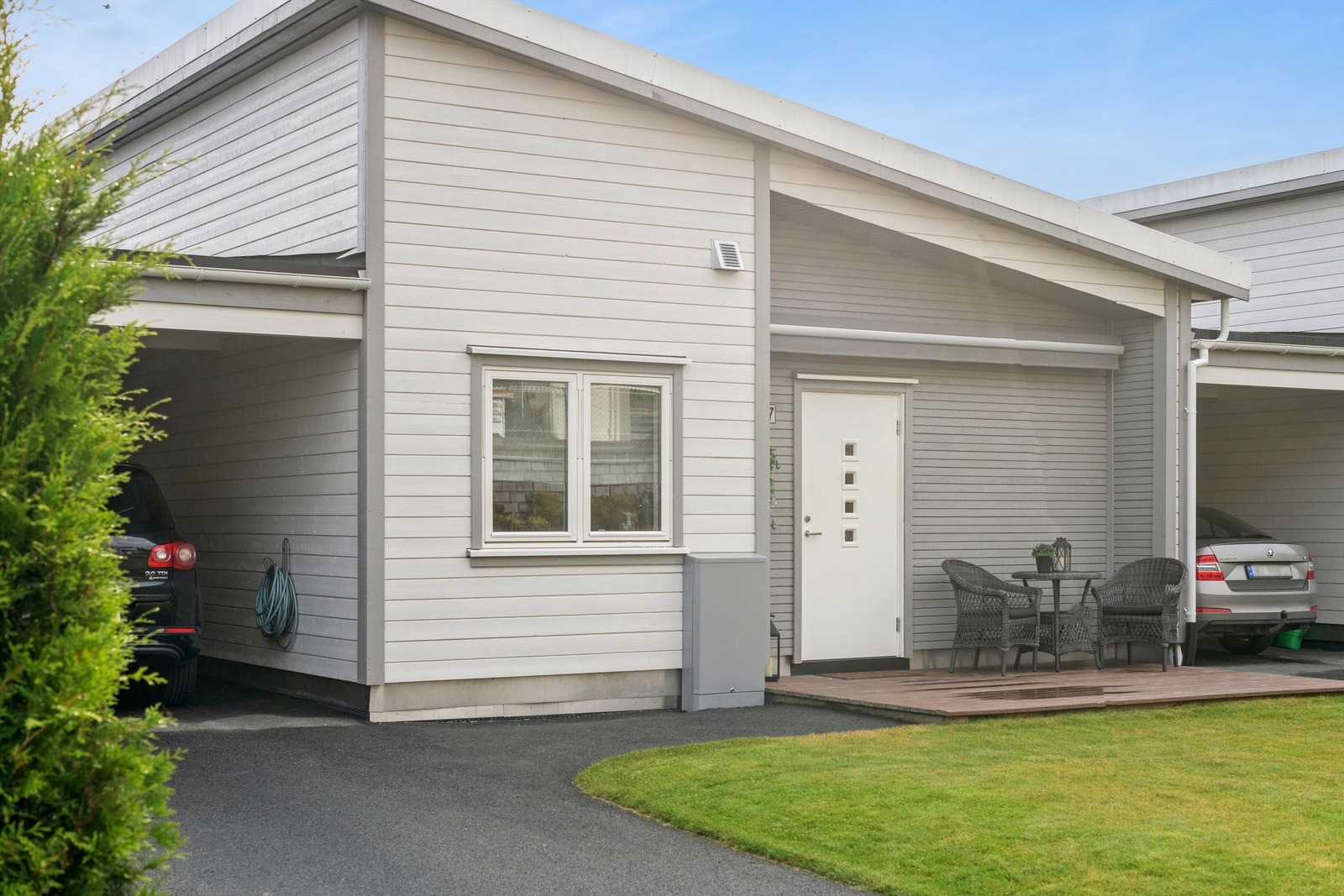 Ved inngangspartiet er det en terrasse på 10 m² og en lettstelt plen. Galleribilde