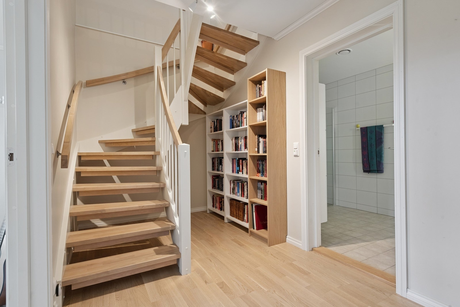 En solid tretrapp med håndløper på veggen leder ned til boligens sokkeletasje. Galleribilde