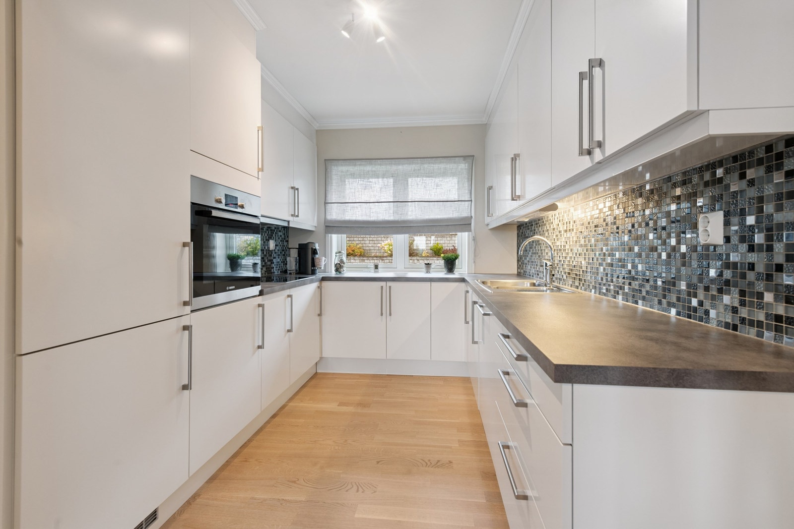 Innredningen har slette fronter og her er alle hvitevarer integrert. Galleribilde