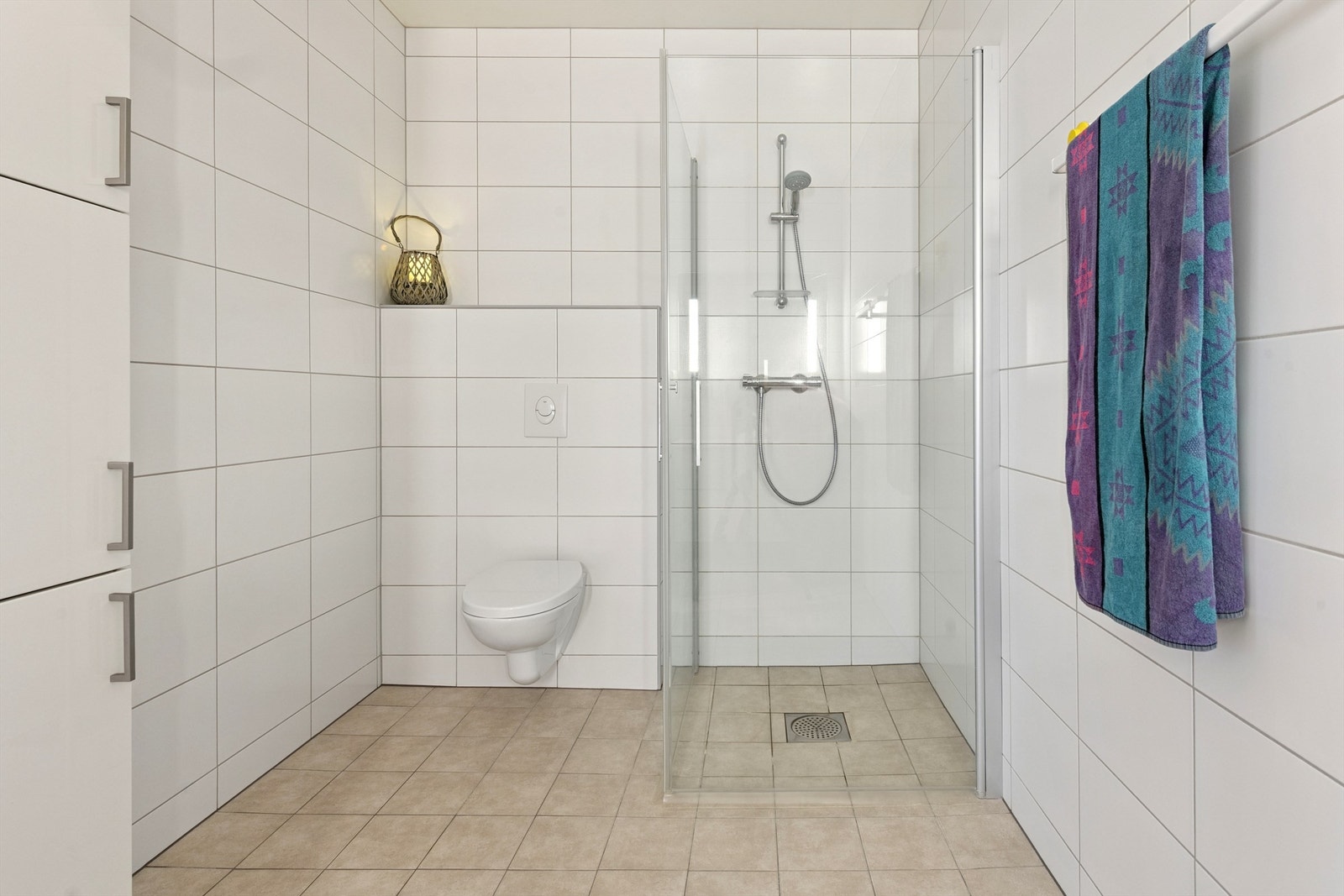 Badet i sokkeletasjen er helfliset og utstyrt med vegghengt toalett og dusjløsning med glassvegger. Galleribilde