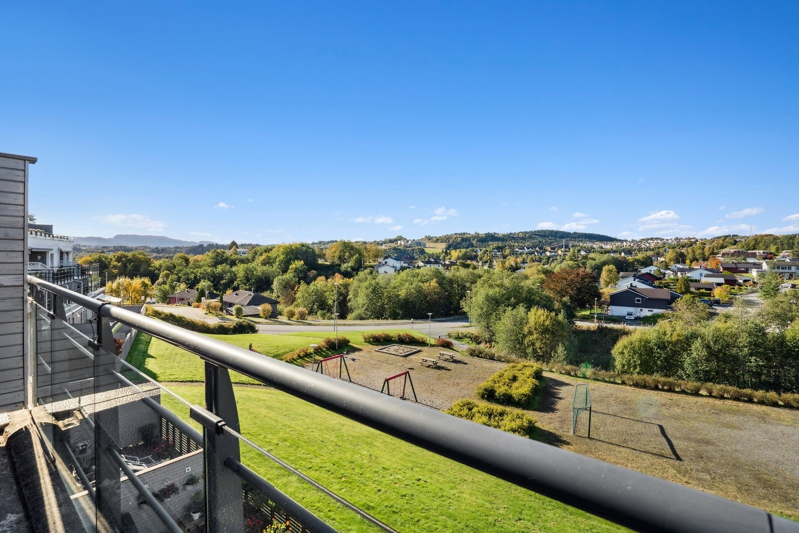 Fra leilighetens balkong kan man nyte den flotte utsikten utover det hyggelige nabolaget. Galleribilde