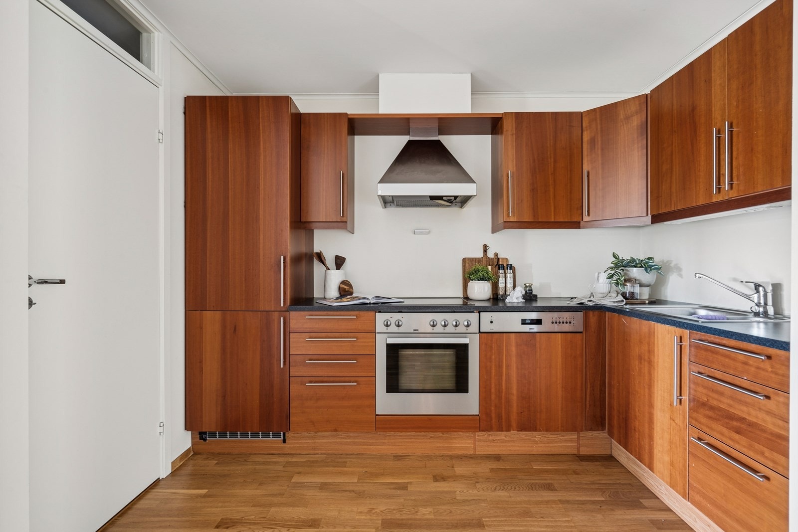 Pen kjøkkeninnredning med folierte skrog, slette fronter og laminert benkeplate. Galleribilde