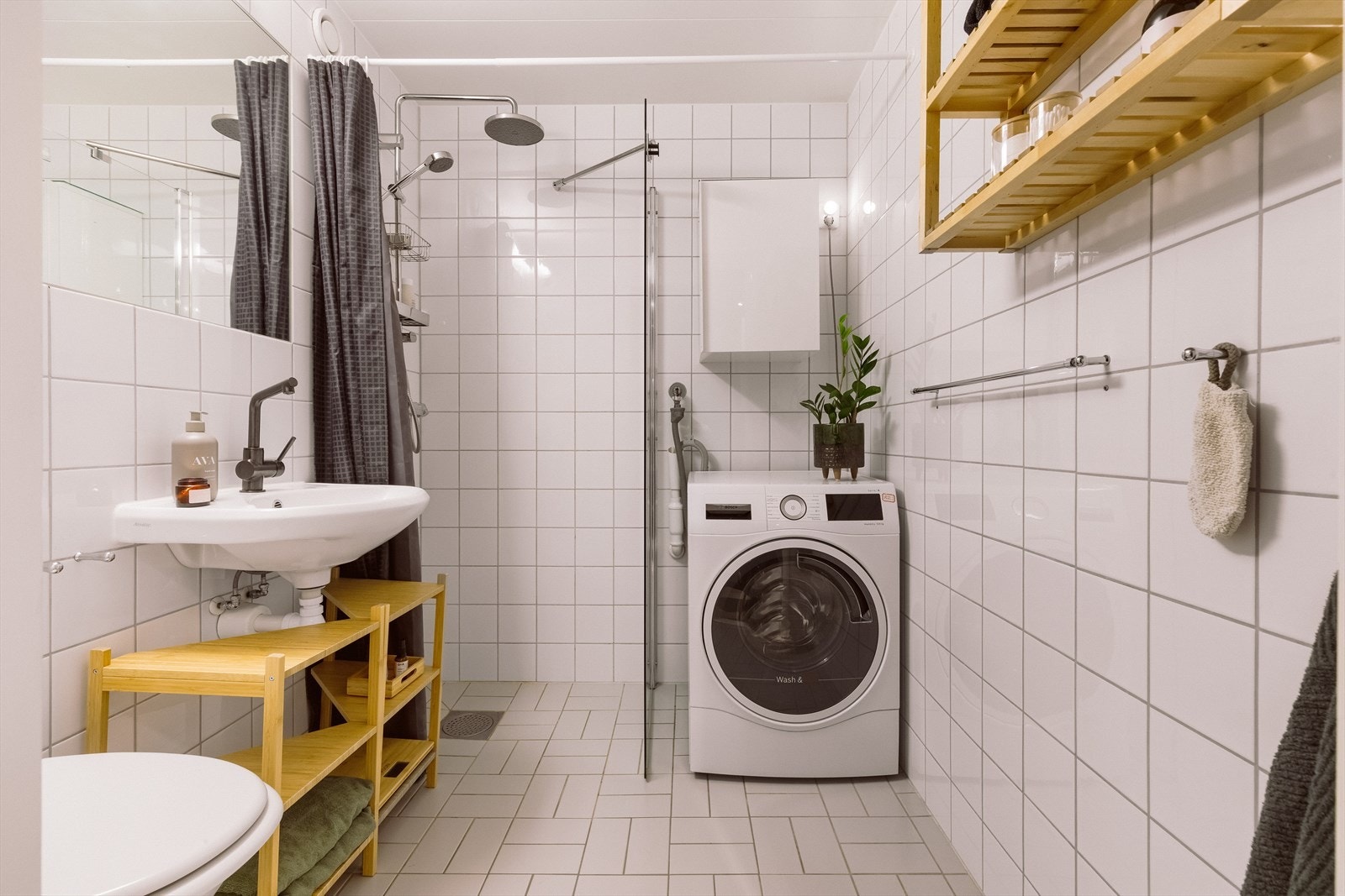Pent og tidløst bad med lyse fliser på gulv og vegger. Galleribilde