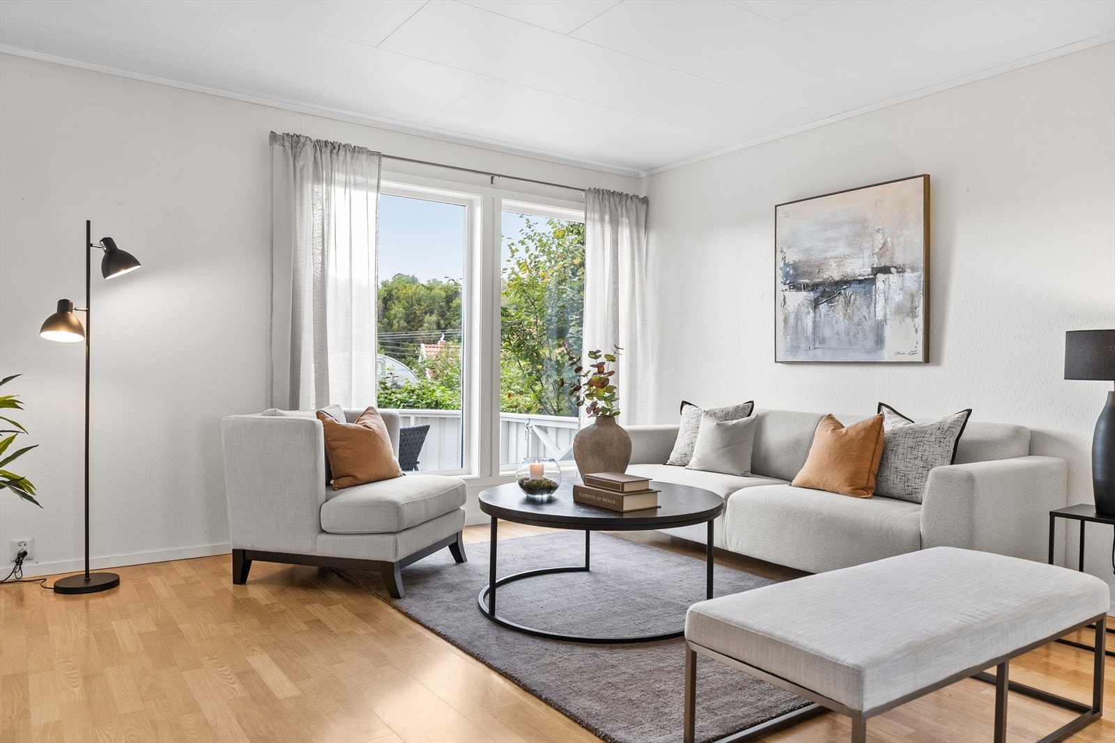 Stuen fremstår som et lyst og innbydende oppholdsrom med laminat på gulvet, lyse malte vegger og malt tak som gir et tidløst og stilrent uttrykk. Galleribilde