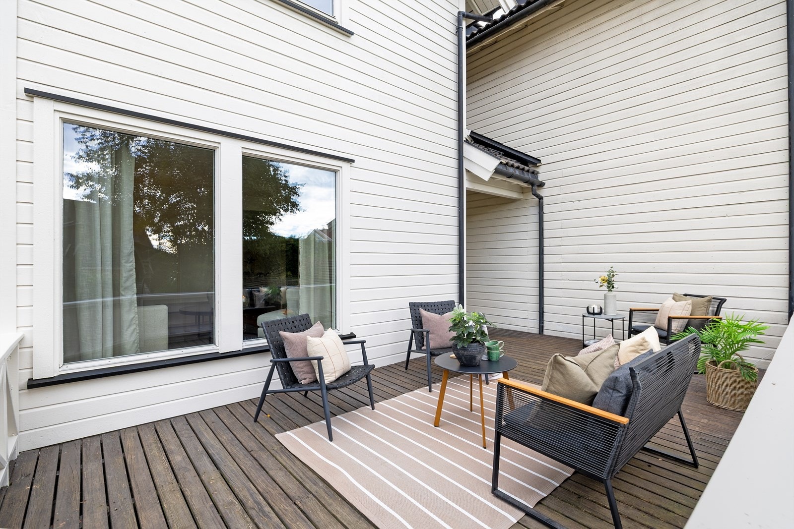 Her er det god plass til spisebord, loungemøbler, grill og frodige blomsterkasser - alt som skal til for å skape en hyggelig atmosfære. Galleribilde