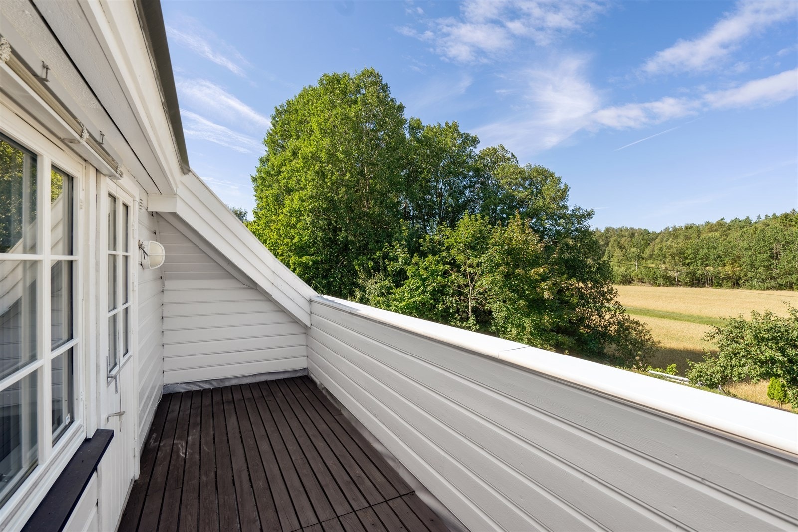 Balkong ut mot dyrket mark og fine grøntområder. Galleribilde