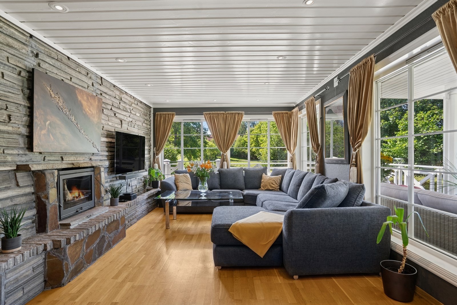 Det er mye lysinnslipp fra de store vinduene i stuen. I den store stuen er det en stor peis i naturstein. Galleribilde