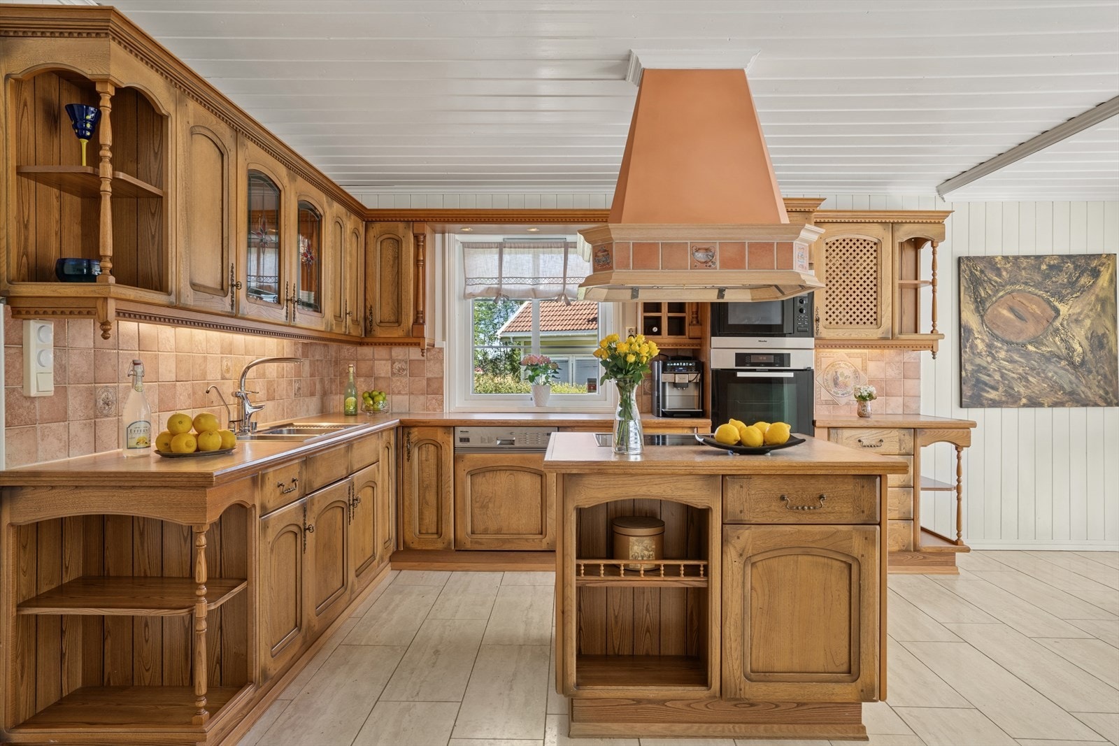 Kjøkkenet har innredning med profilerte fronter og en frittstående øy med tilsvarende overflater. Kjøkkeninnredningen er fra byggeåret. Benkeplaten er av laminat med heltre endelister. Galleribilde