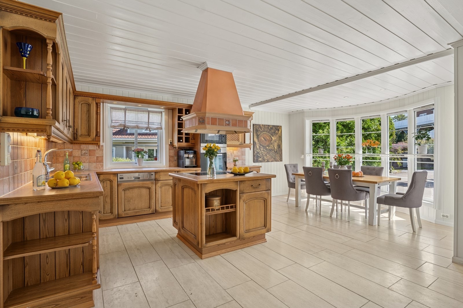 Det er stort spisekjøkken. Fliser på gulvet og karnapp ut mot gårdsplassen. Galleribilde