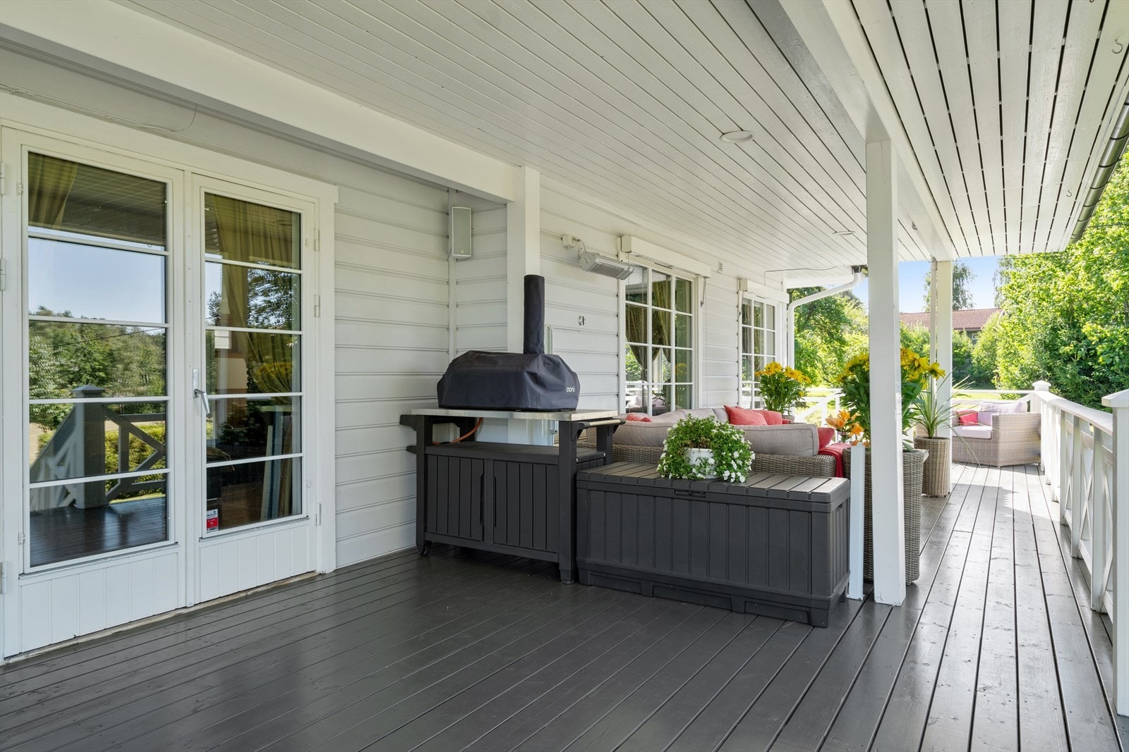 Overbygget terrasse med utgang fra stuen. Det er strømuttak, varmelampe og høyttaler. Galleribilde