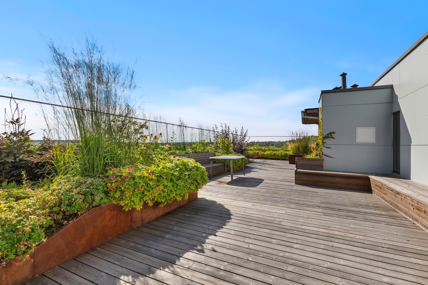 På taket finner man en felles takterrasse som er pent opparbeidet med grønne planter i plantekasser, benker og sosiale soner. Galleribilde