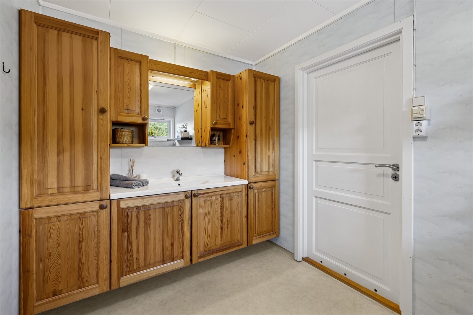 Rommet er innredet med servant med tilhørende skapplass, gulvmontert toalett og dusjforheng. Galleribilde