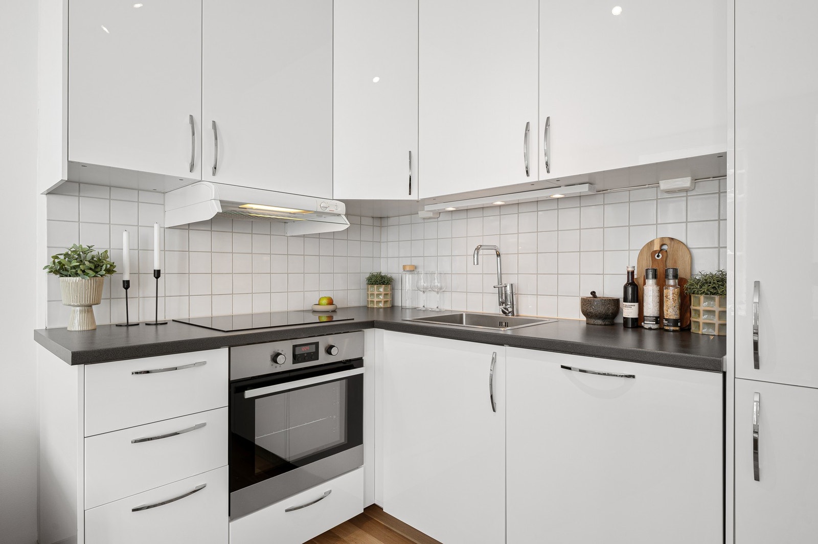 Kjøkkenet inneholder integrerte hvitevarer som platetopp, stekeovn, oppvaskmaskin og kjøl/frys. Galleribilde