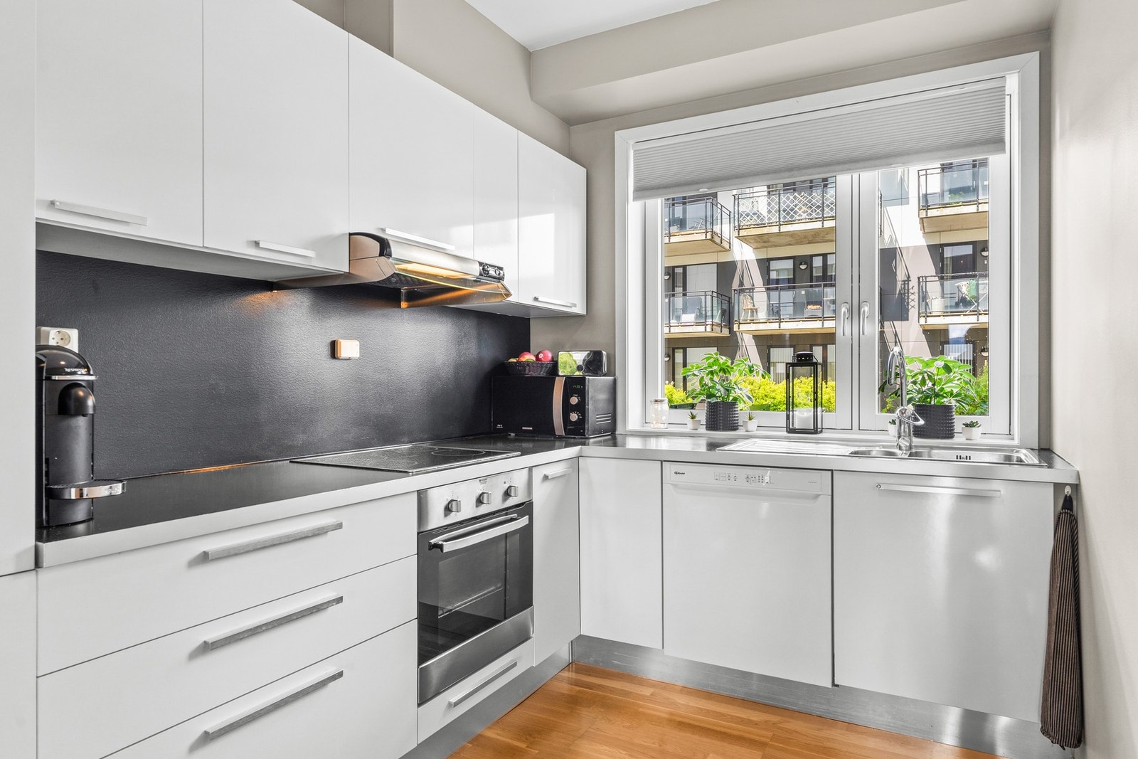 Pent kjøkken med integrerte hvitevarer og mye skap- og benkeplass. Galleribilde