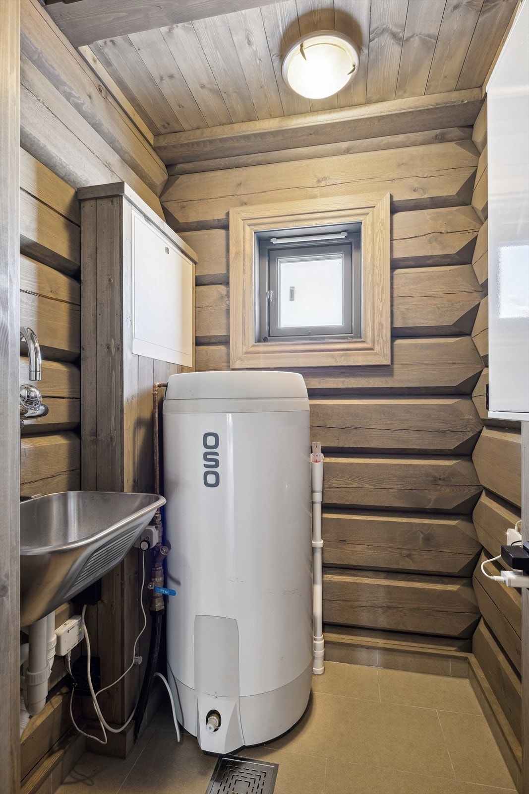 Praktisk, separat vaskerom med flis på gulvflater, tømmer vegger og panel i himling. -foto fra en oppsatt tilsvarende hytte. Galleribilde