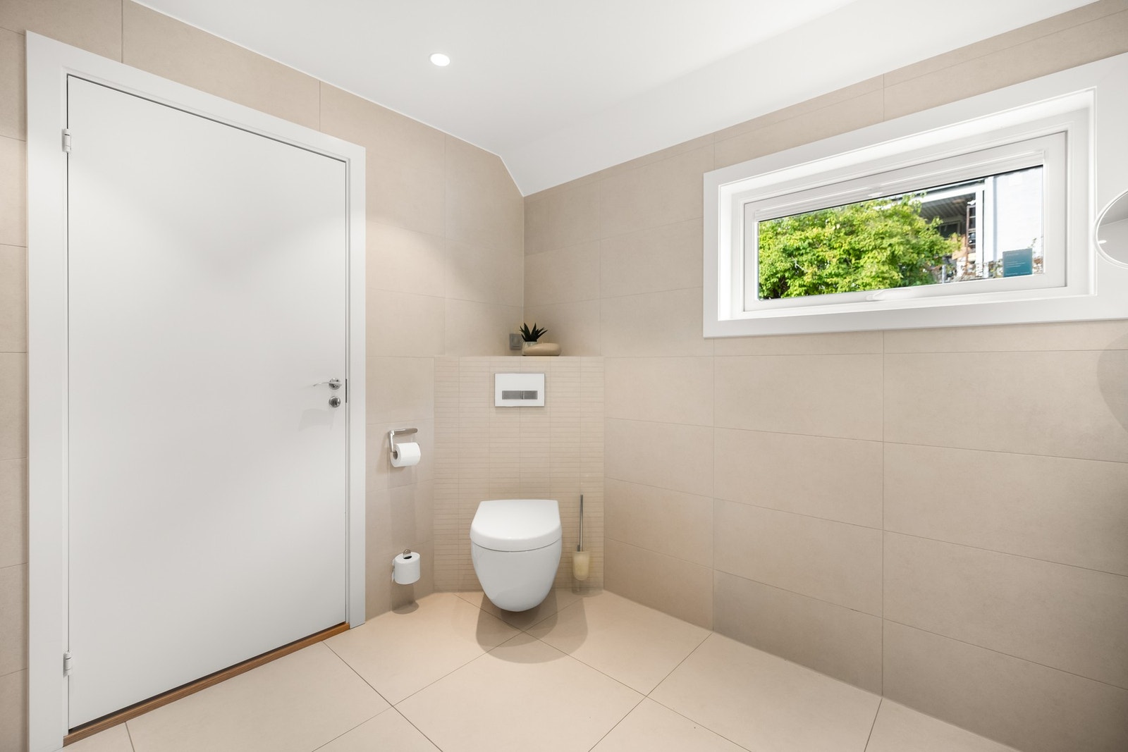 Videre inneholder badet vegghengt toalett med innebygget sisterne og dusjhjørne med glassvegger og hånd-/regnfallsdusj. Galleribilde