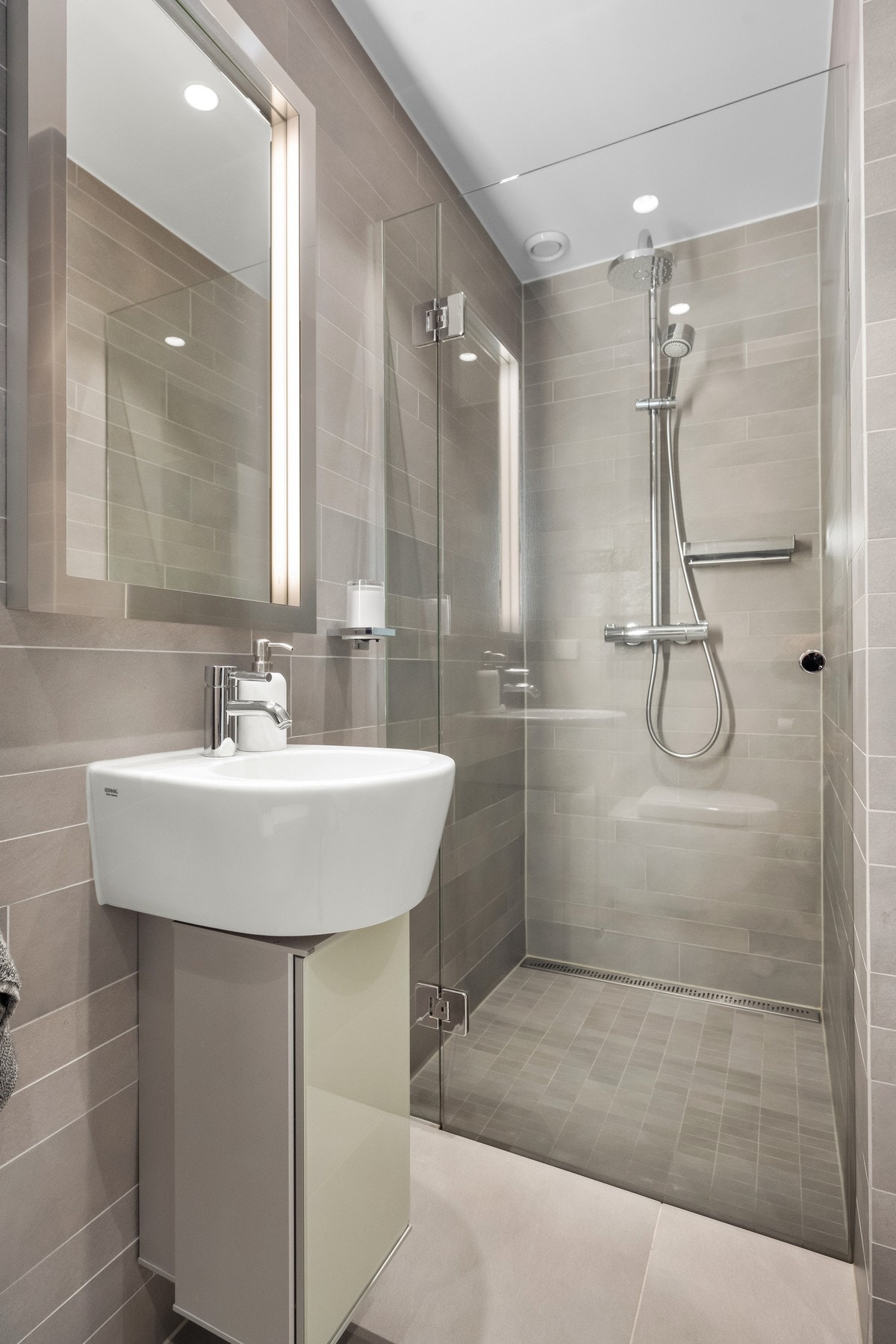 Badet har flislagte vegg- og gulvflater med behagelig gulvvarme og downlights i himling Galleribilde
