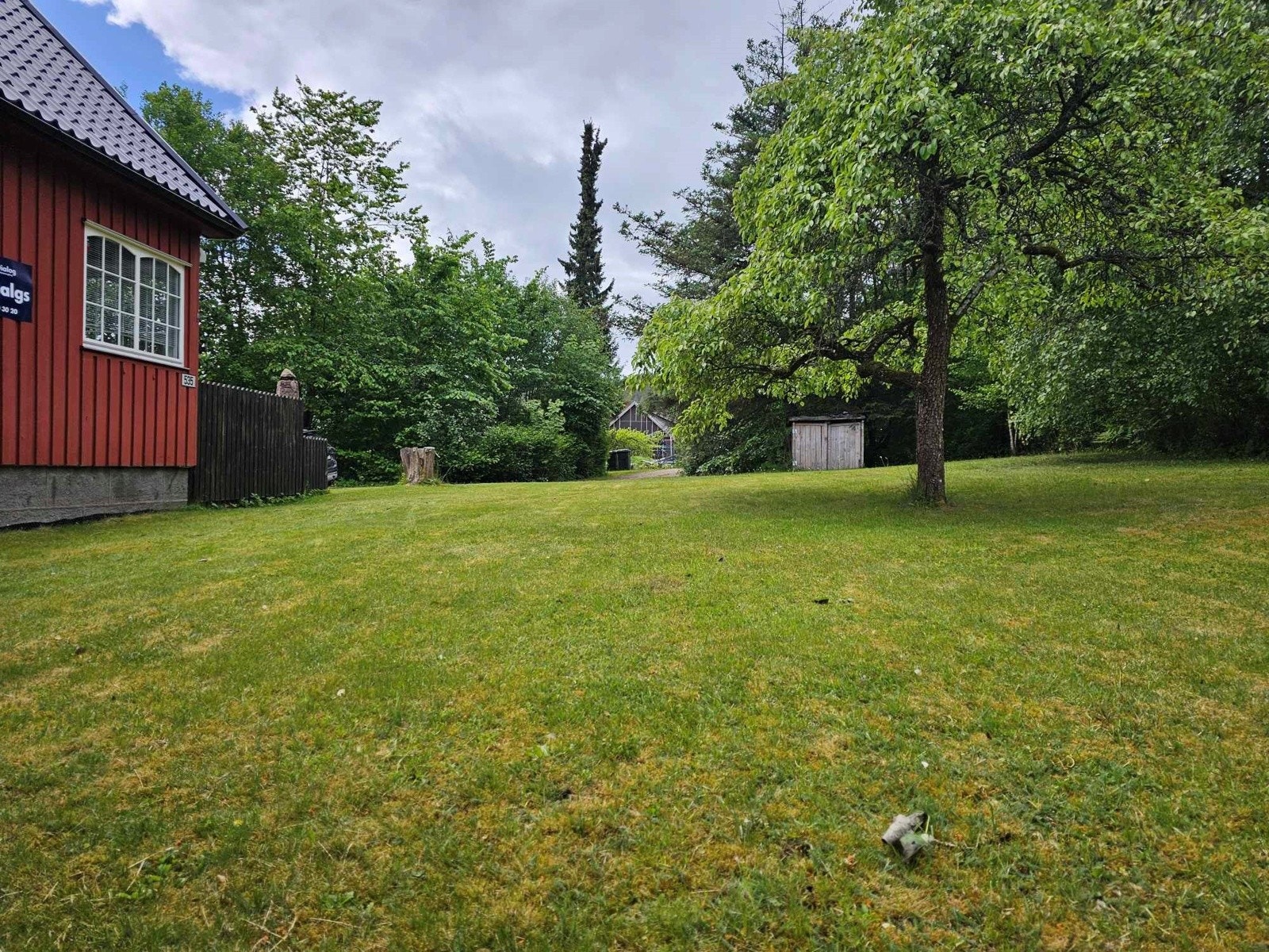 Eiendommen er pent opparbeidet og omkranset av beplantning Galleribilde