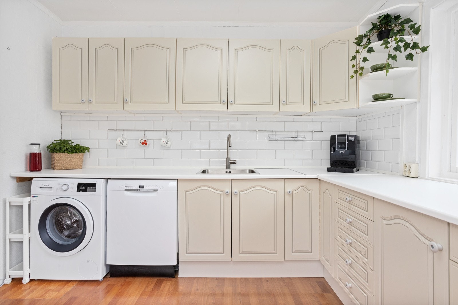 Plass til spisegruppe på kjøkkenet. Frittstående hvitevarer herunder ovn med koketopp, oppvaskmaskin og vaskemaskin. Galleribilde