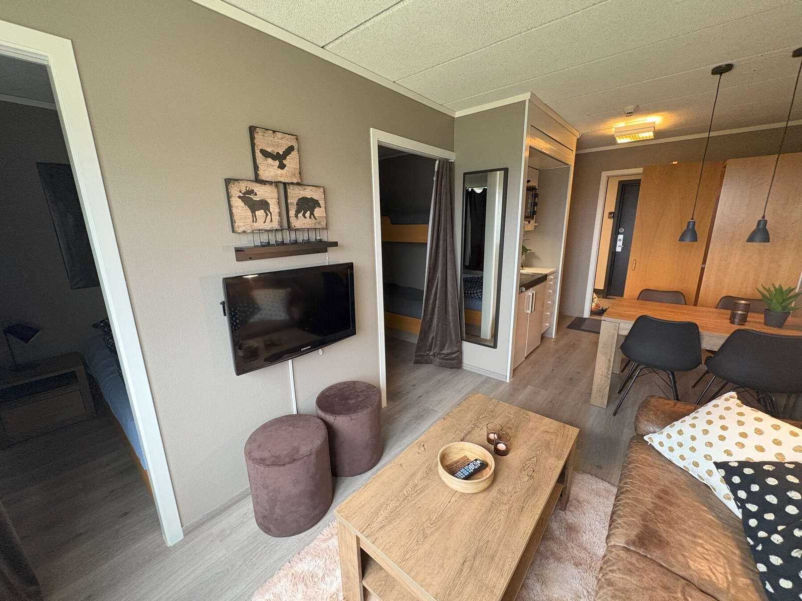 Lys stue med laminatgulv og lyse vegger. Inngang inn til soverommet. Galleribilde