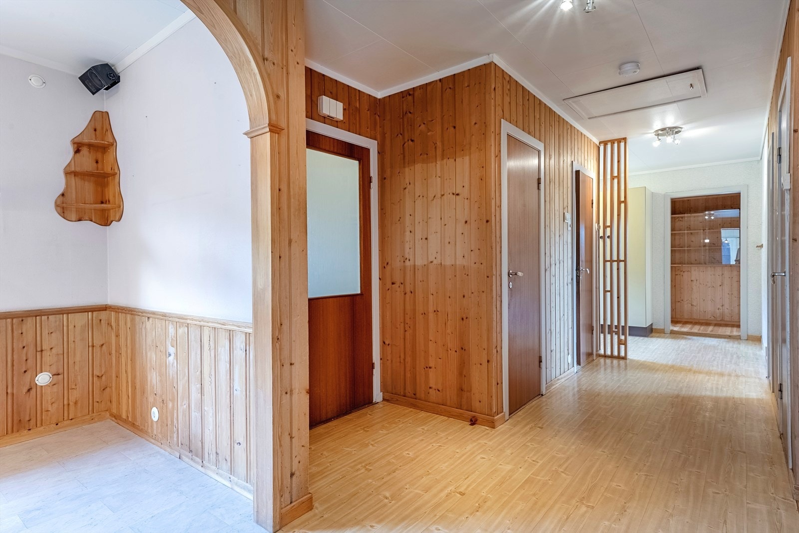 Romslig entré med inngang til stue og kjøkken samt soveromsfløy i motsatt ende av huset Galleribilde