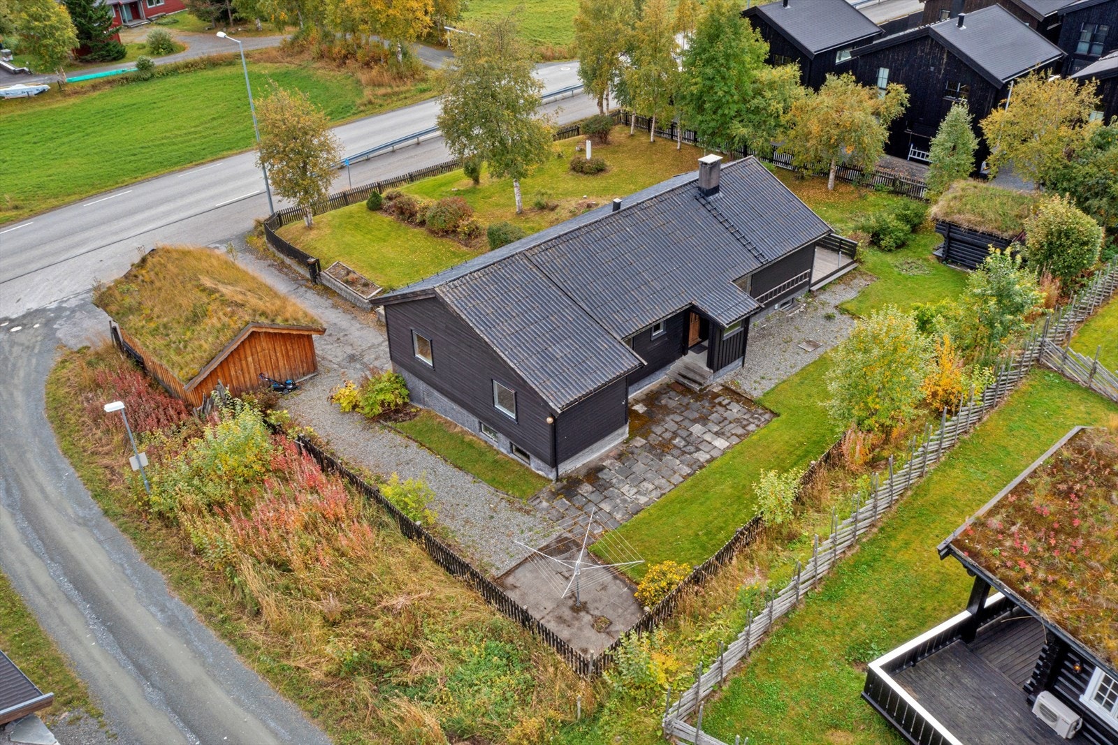 Romslig eiertomt på ca. 1,2 mål opparbeidet med plen, beplantning, asfaltert gårdsplass m.m. og innrammet med stakittgjerde Galleribilde