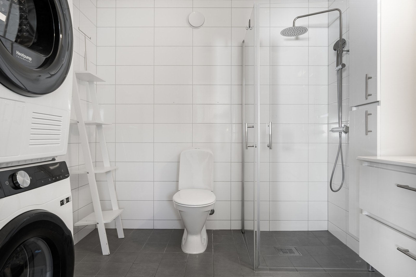 Badet er innredet med dusjnisje, servant med underskap, toalett og opplegg for vaskemaskin. Galleribilde
