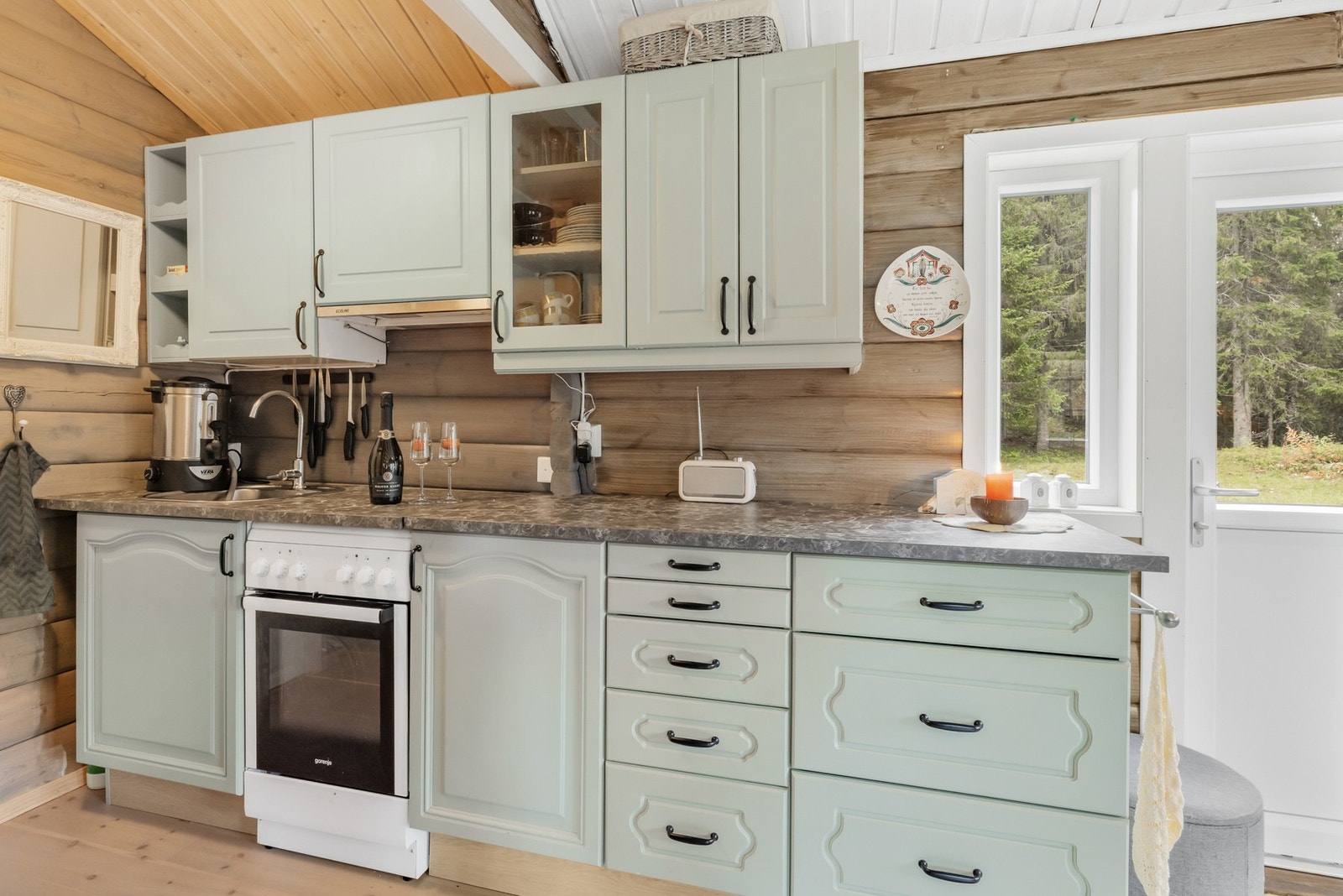 Hyttekjøkken i dus pastell som står godt til de lune panelveggene Galleribilde