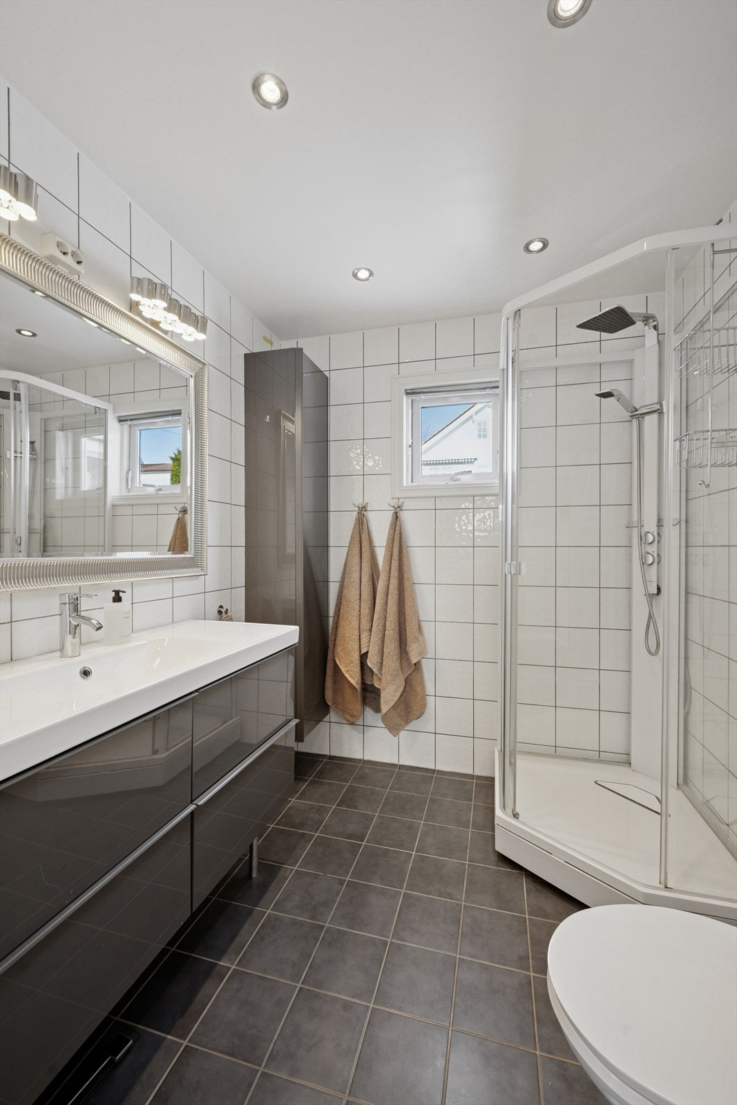 Flott baderom 1.etg. har innredning med nedfelt servant, veggmontert toalett og dusjkabinett. Det er balansert ventilasjon. Galleribilde