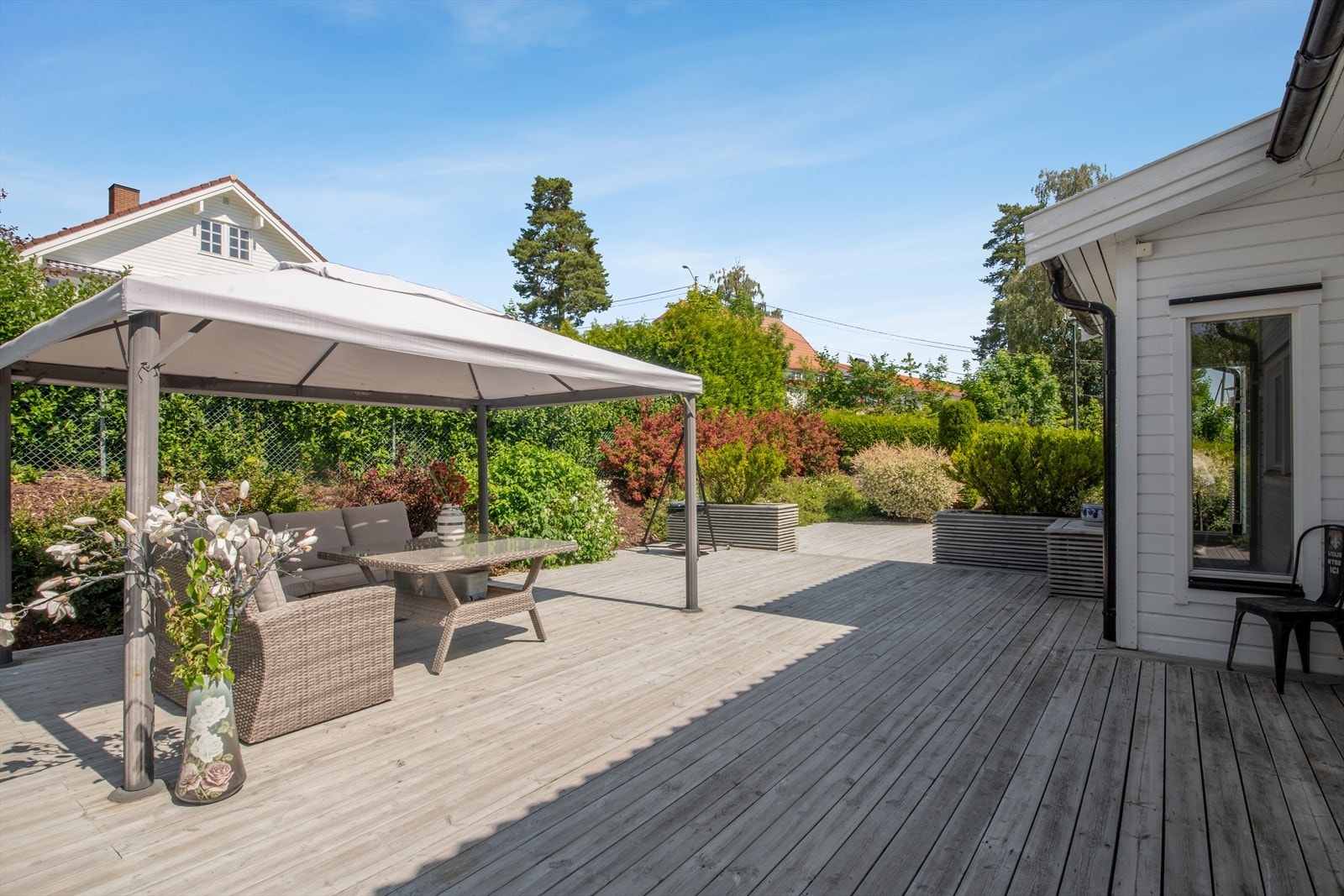 Meget romslig og flott terrasse med platting på baksiden av boligen. Galleribilde