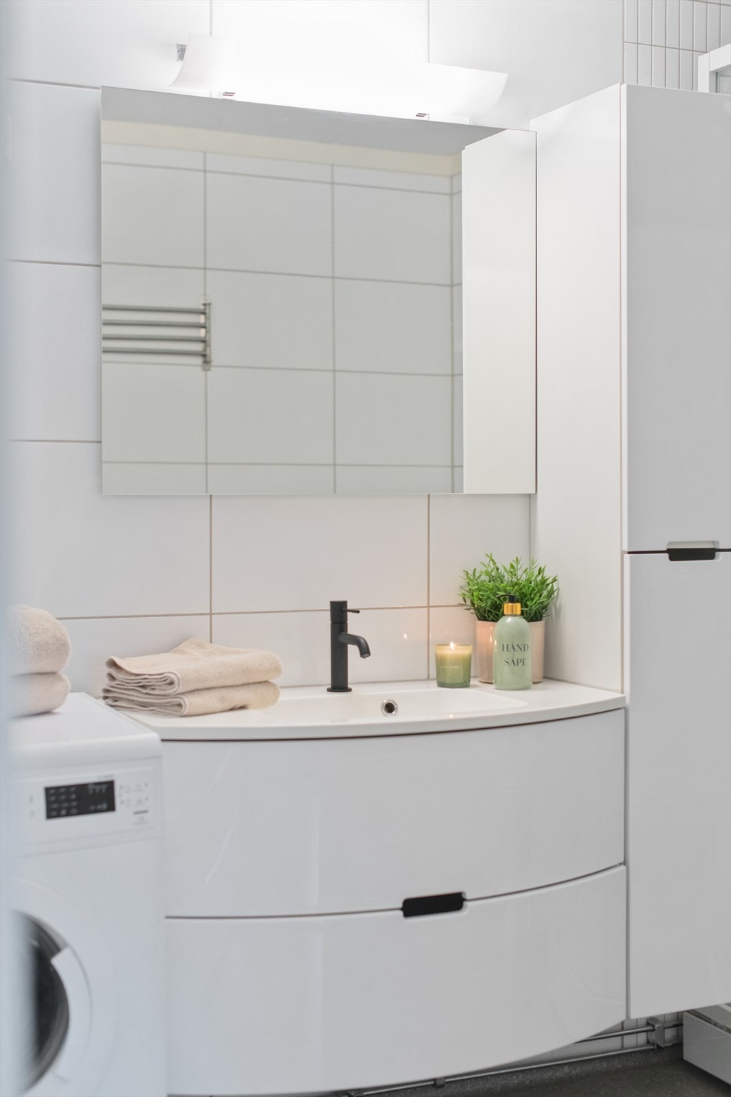 Badet har heldekkende servant i innredning, høyskap og speil med overlys. Galleribilde