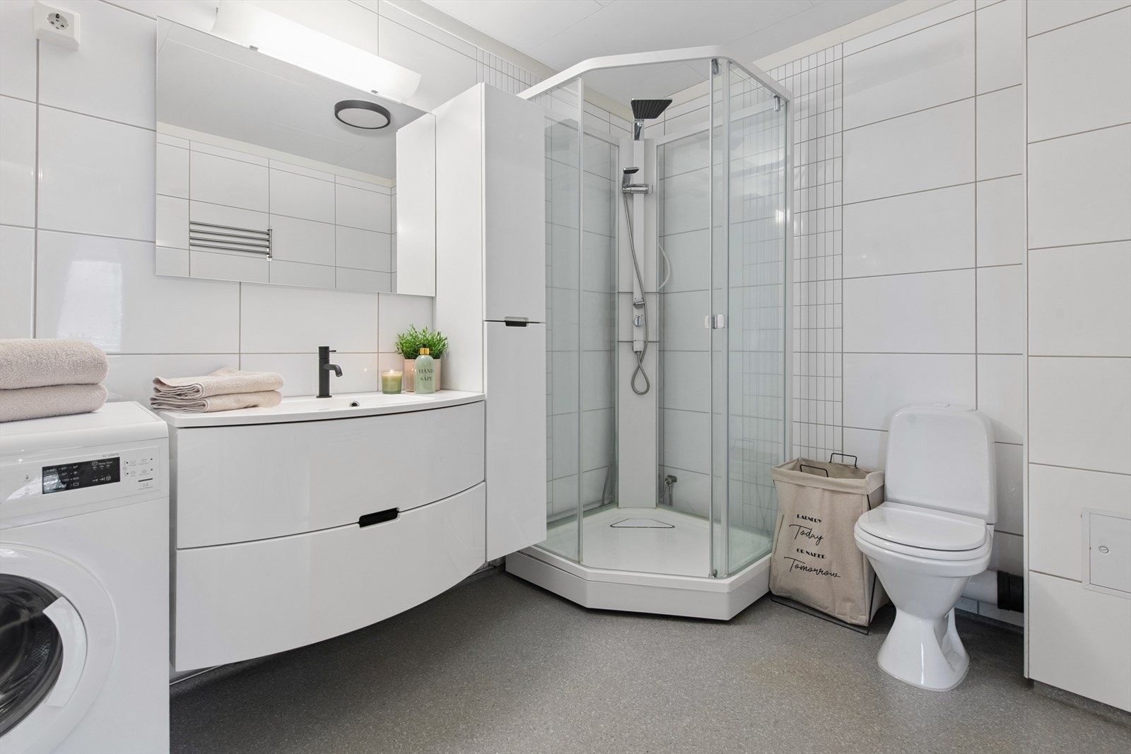 Lekkert bad med dusjhjørne og opplegg for vaskemaskin. Galleribilde