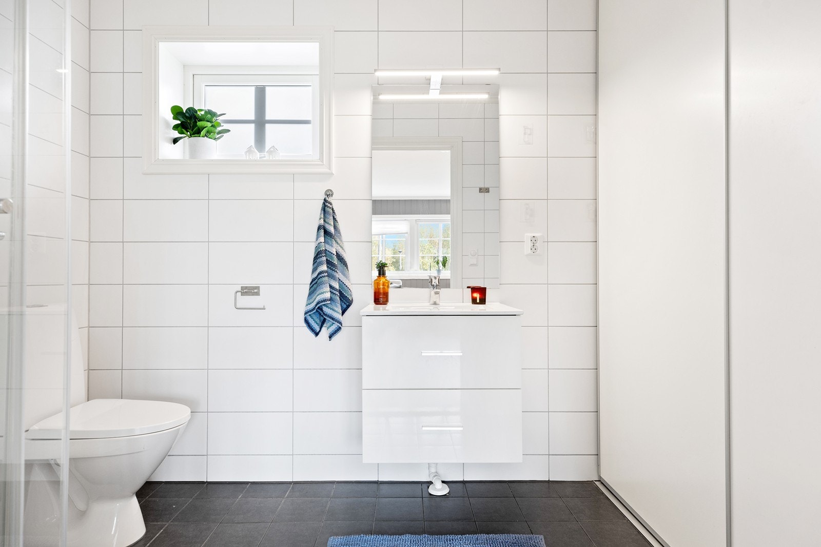 Bad/vaskerom i utleiedel har dusjkabinett, wc, servant samt opplegg for vaskemaskin Galleribilde